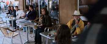 Movie still from “The Bourne Ultimatum” (2007), directed by Paul Greengrass – A group of people sitting at a table with plates of food on it; Wide shot, Over the shoulder angle