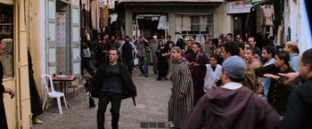Movie still from “The Bourne Ultimatum” (2007), directed by Paul Greengrass – A crowd of people walking down a street; Wide shot, Over the shoulder angle