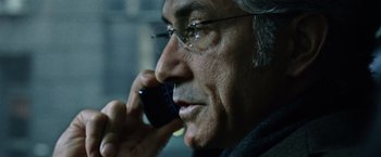 Movie still from “The Bourne Ultimatum” (2007), directed by Paul Greengrass – An older man talking on a cell phone while wearing glasses; Close Up shot, Low angle