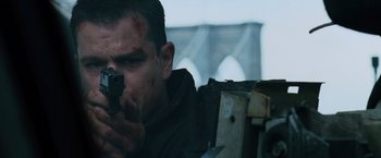 Movie still from “The Bourne Ultimatum” (2007), directed by Paul Greengrass – A man is holding a gun in his hand; Close Up shot, Low angle