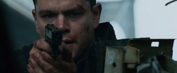 Movie still from “The Bourne Ultimatum” (2007), directed by Paul Greengrass – A person holding a gun; Close Up shot, Low angle