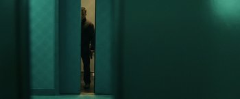 Movie still from “The Bourne Ultimatum” (2007), directed by Paul Greengrass – A man standing in a doorway with a knife in his hand; Wide shot, Low angle