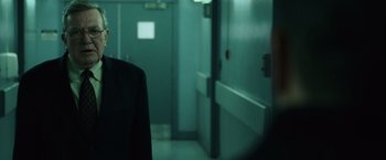 Movie still from “The Bourne Ultimatum” (2007), directed by Paul Greengrass – A person standing in front of a door way; Close Up shot, Over the shoulder angle