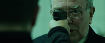 Movie still from “The Bourne Ultimatum” (2007), directed by Paul Greengrass – An older man taking a picture with a cell phone; Close Up shot, Over the shoulder angle