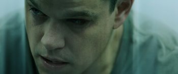 Movie still from “The Bourne Ultimatum” (2007), directed by Paul Greengrass – A man's face in a dark room; Close Up shot, High angle