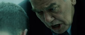 Movie still from “The Bourne Ultimatum” (2007), directed by Paul Greengrass – An older man is looking down at his cell phone; Extreme Close Up shot, Over the shoulder angle