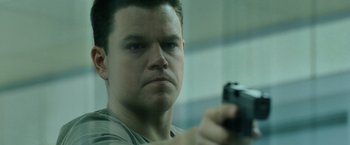 Movie still from “The Bourne Ultimatum” (2007), directed by Paul Greengrass – A person holding a gun; Close Up shot, Low angle