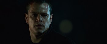 Movie still from “The Bourne Ultimatum” (2007), directed by Paul Greengrass – A person wearing a black shirt; Close Up shot, Low angle