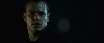 Movie still from “The Bourne Ultimatum” (2007), directed by Paul Greengrass – A person wearing a black shirt; Close Up shot, Low angle
