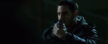 Movie still from “The Bourne Ultimatum” (2007), directed by Paul Greengrass – A man holding a gun in his hands; Close Up shot, Over the shoulder angle