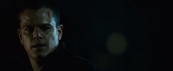 Movie still from “The Bourne Ultimatum” (2007), directed by Paul Greengrass – A person wearing a black shirt; Close Up shot, Low angle