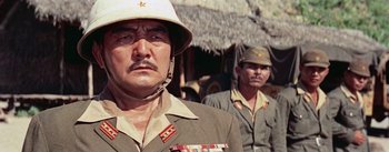 Movie still from “The Bridge on the River Kwai” (1957), directed by David Lean – Two men in military uniforms standing next to each other; Close Up shot, Low angle