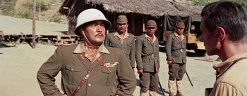 Movie still from “The Bridge on the River Kwai” (1957), directed by David Lean – A group of men standing next to each other in uniform; Medium shot, Low angle
