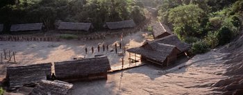 Movie still from “The Bridge on the River Kwai” (1957), directed by David Lean – An aerial view of people walking around a village; Extreme Wide shot, High angle