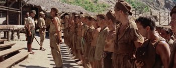 Movie still from “The Bridge on the River Kwai” (1957), directed by David Lean – A group of men standing next to each other on top of a hill; Wide shot, Low angle