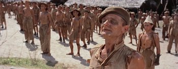 Movie still from “The Bridge on the River Kwai” (1957), directed by David Lean – A group of men standing next to each other on a dirt road; Medium shot, Low angle