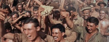 Movie still from “The Bridge on the River Kwai” (1957), directed by David Lean – A group of men in brown shirts and hats; Medium shot, High angle