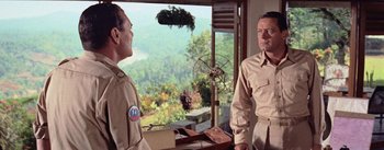 Movie still from “The Bridge on the River Kwai” (1957), directed by David Lean – Two men standing next to each other in front of a window; Medium shot, Over the shoulder angle