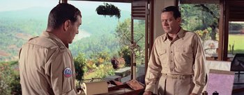 Movie still from “The Bridge on the River Kwai” (1957), directed by David Lean – A man standing in front of a window looking at another man in front of him; Medium shot, Over the shoulder angle