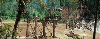 Movie still from “The Bridge on the River Kwai” (1957), directed by David Lean – A group of people standing next to a wooden structure; Extreme Wide shot, High angle