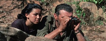 Movie still from “The Bridge on the River Kwai” (1957), directed by David Lean – A man and a woman looking at something through a camera; Close Up shot, Over the shoulder angle