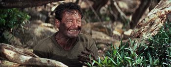 Movie still from “The Bridge on the River Kwai” (1957), directed by David Lean – A person wearing a shirt with mud all over his face; Close Up shot, High angle