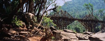 Movie still from “The Bridge on the River Kwai” (1957), directed by David Lean – A bridge that is built into the side of a mountain; Extreme Wide shot, Low angle