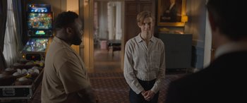 Movie still from “The Bubble” (2022), directed by Judd Apatow – A man standing next to another man in a room; Medium shot, Over the shoulder angle