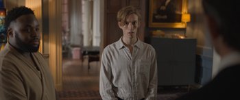 Movie still from “The Bubble” (2022), directed by Judd Apatow – A man in a white shirt is standing in a room; Medium shot, Low angle