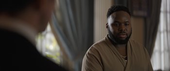 Movie still from “The Bubble” (2022), directed by Judd Apatow – A man with a beard is sitting in a room; Close Up shot, Over the shoulder angle