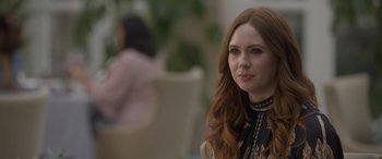 Movie still from “The Bubble” (2022), directed by Judd Apatow – A woman with long red hair sitting at a table; Close Up shot, Over the shoulder angle