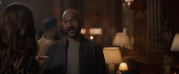 Movie still from “The Bubble” (2022), directed by Judd Apatow – A man with a bald head is standing in a room; Medium shot, Over the shoulder angle