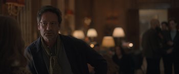 Movie still from “The Bubble” (2022), directed by Judd Apatow – A man standing in front of a group of people in a room; Close Up shot, Over the shoulder angle