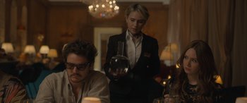 Movie still from “The Bubble” (2022), directed by Judd Apatow – A woman in a black jacket is holding a wine glass; Medium shot, Over the shoulder angle