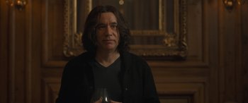 Movie still from “The Bubble” (2022), directed by Judd Apatow – A man with long hair is holding a glass of wine; Close Up shot, Over the shoulder angle