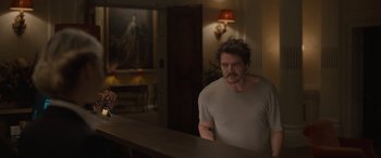 Movie still from “The Bubble” (2022), directed by Judd Apatow – A man standing in front of a mirror in a room; Medium shot, Over the shoulder angle