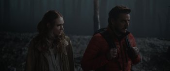 Movie still from “The Bubble” (2022), directed by Judd Apatow – A man and a woman standing next to each other in the dark; Medium shot, Over the shoulder angle