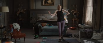 Movie still from “The Bubble” (2022), directed by Judd Apatow – A woman standing in front of a couch in a living room; Wide shot, Over the shoulder angle