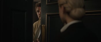 Movie still from “The Bubble” (2022), directed by Judd Apatow – A man standing in front of a woman holding a knife; Medium shot, Over the shoulder angle