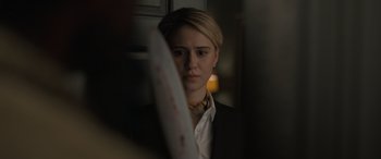 Movie still from “The Bubble” (2022), directed by Judd Apatow – A woman in a suit and tie holding a knife in front of her face; Close Up shot, Over the shoulder angle