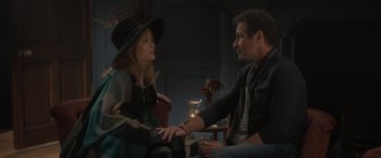 Movie still from “The Bubble” (2022), directed by Judd Apatow – A man and a woman sitting on a couch; Medium shot, Over the shoulder angle