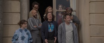 Movie still from “The Bubble” (2022), directed by Judd Apatow – A group of people standing next to each other in front of a window; Medium shot, Over the shoulder angle