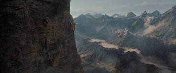 Movie still from “The Bubble” (2022), directed by Judd Apatow – A man climbing a rock wall in the mountains; Extreme Wide shot, Low angle