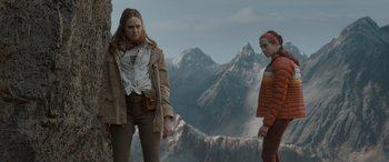 Movie still from “The Bubble” (2022), directed by Judd Apatow – Two women standing in front of a mountain range; Medium shot, Low angle