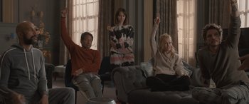 Movie still from “The Bubble” (2022), directed by Judd Apatow – A group of people sitting in a living room watching tv; Medium shot, High angle