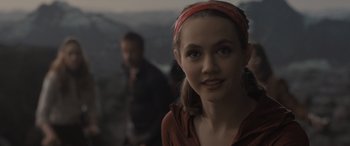 Movie still from “The Bubble” (2022), directed by Judd Apatow – A woman with a red head band is smiling; Close Up shot, Over the shoulder angle