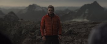 Movie still from “The Bubble” (2022), directed by Judd Apatow – A man in a red jacket standing on top of a hill; Medium shot, Over the shoulder angle