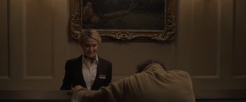 Movie still from “The Bubble” (2022), directed by Judd Apatow – A woman standing next to a man in front of a painting; Medium shot, Over the shoulder angle