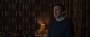 Movie still from “The Bubble” (2022), directed by Judd Apatow – A man standing in front of a book shelf; Medium shot, Over the shoulder angle