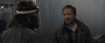 Movie still from “The Bubble” (2022), directed by Judd Apatow – A man in a brown jacket talking to another man; Close Up shot, Over the shoulder angle